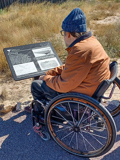 A visitor to Fort Craig reads an interpretive panel along the trail.