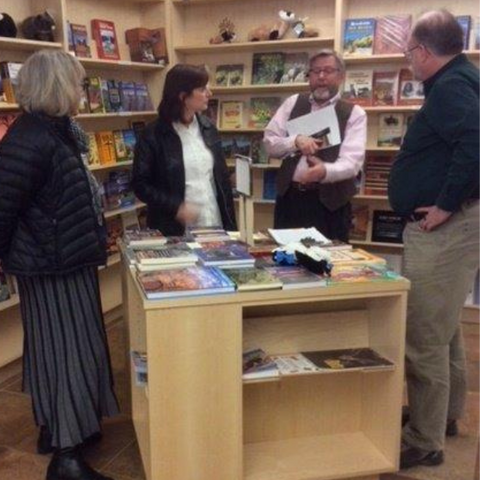 A PLIA employee talks to customers about books for sale at the Public Lands Information Center in Santa Fe, New Mexico.